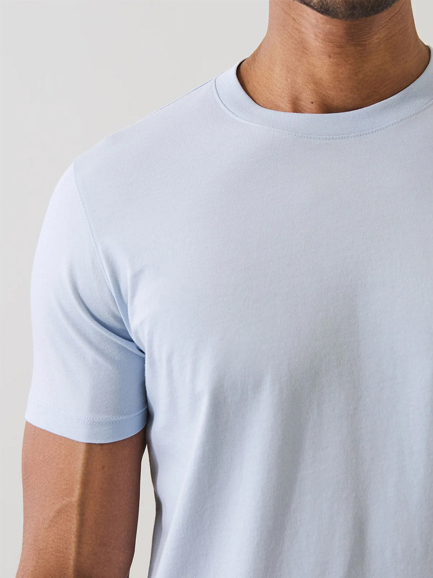 A person wearing the Patrick Assaraf Organic Pima Cotton High Neck T-Shirt in Blue Ice, shown from shoulders to mid-torso against a plain background.