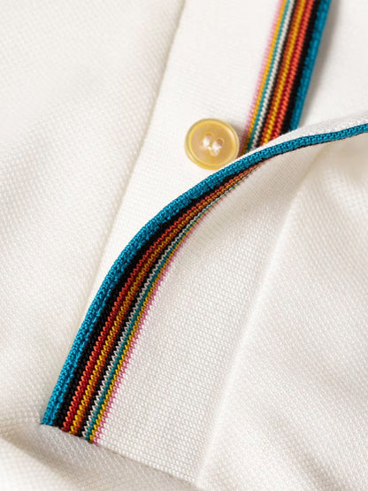 Close-up of the Paul Smith Signature Stripe Trim Polo Shirt in white, featuring a cream textured fabric, yellow button, and Signature Stripe trim along the placket and collar edge.