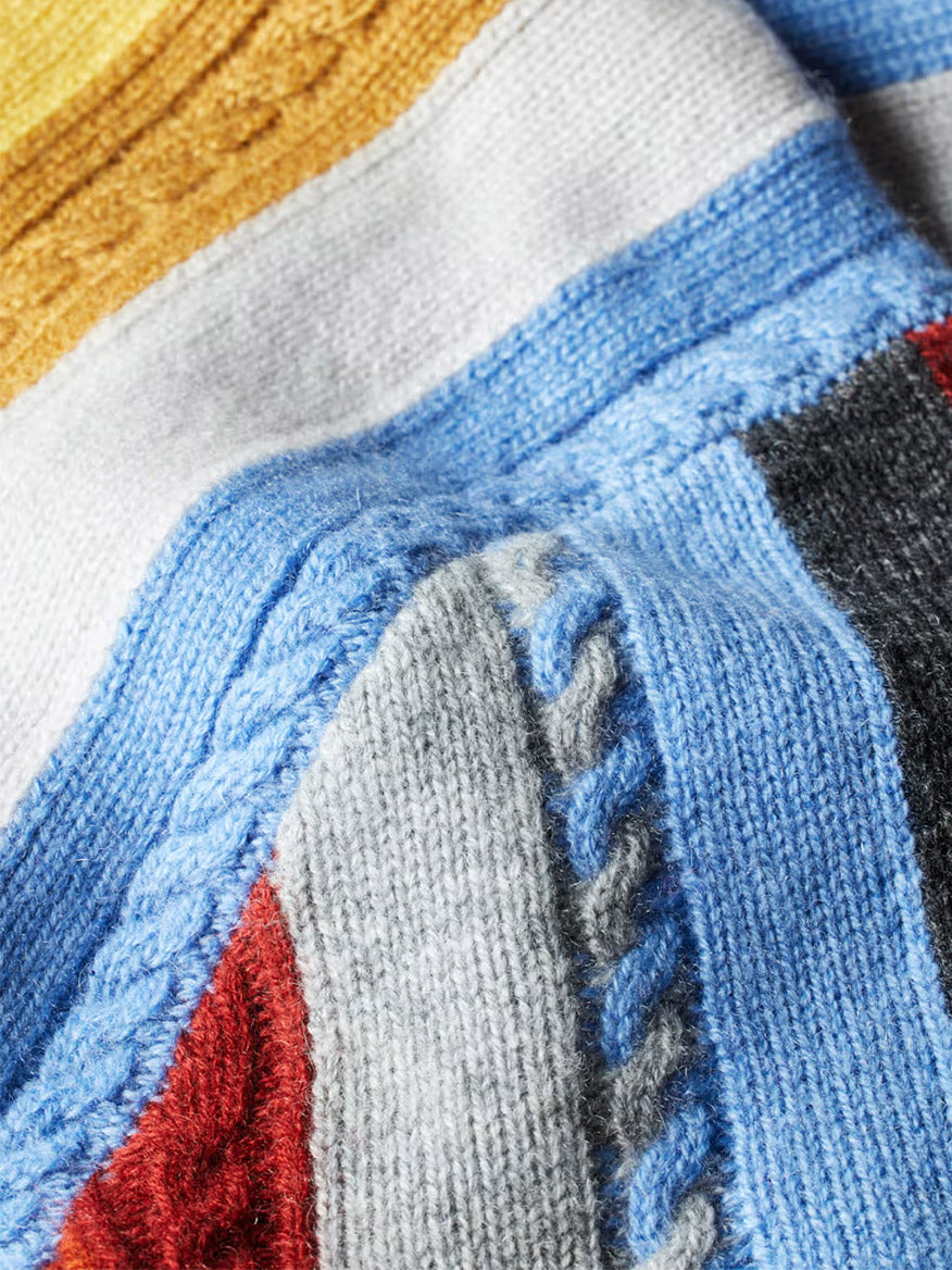 Close-up of the Paul Smith Cashmere-Blend Signature Stripe Sweater in Multi, featuring blue, yellow, white, red, grey, and black cable-knit sections with braided and textured patterns.
