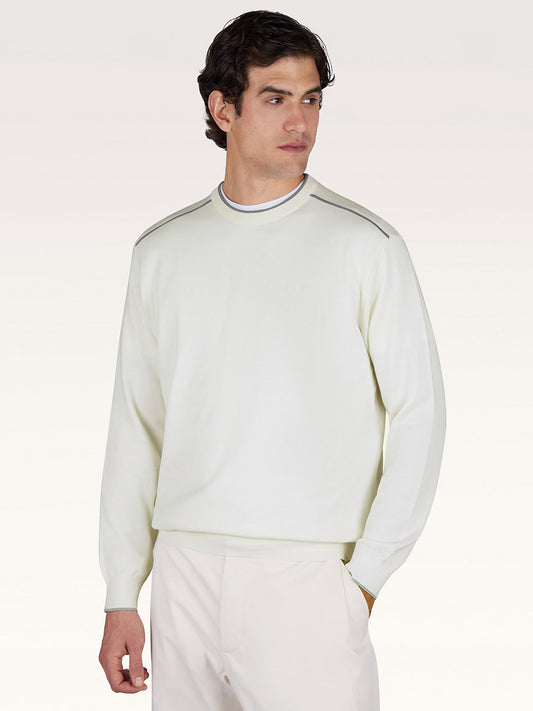 A man wearing the Paul & Shark Crew‑Neck Sweater With Aqualeather Suede Details in white and white pants stands against a plain light background.