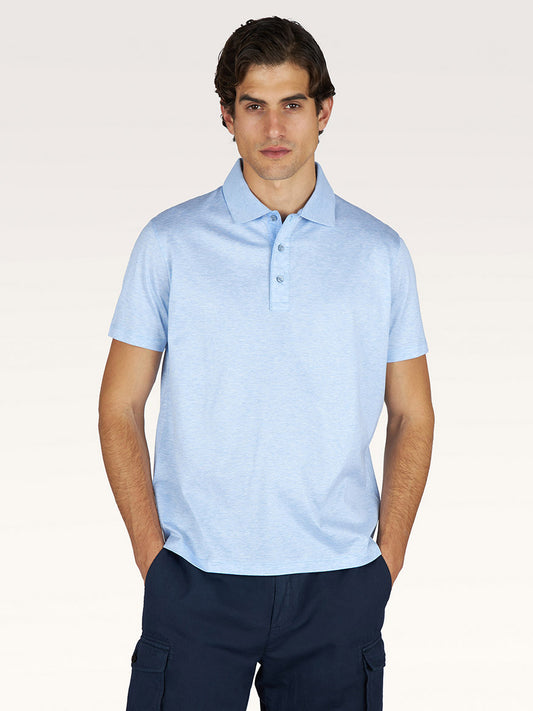 A man stands facing forward, wearing a cerulean Paul & Shark Polo Jersey Shirt with linen details and dark blue cargo pants against a plain light background.