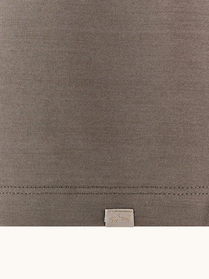 Close-up of the Paul & Shark Polo Jersey Shirt With Linen Details in Morel, showing brown double mercerised cotton fabric, visible stitching near the bottom, and a small beige tag below the seam.