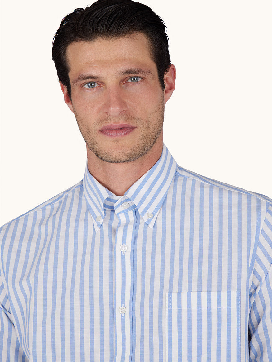 A man wears the Paul & Shark Cotton Poplin Shirt with a white and blue striped pattern, featuring a button-down collar and chest pocket, standing against a plain background.