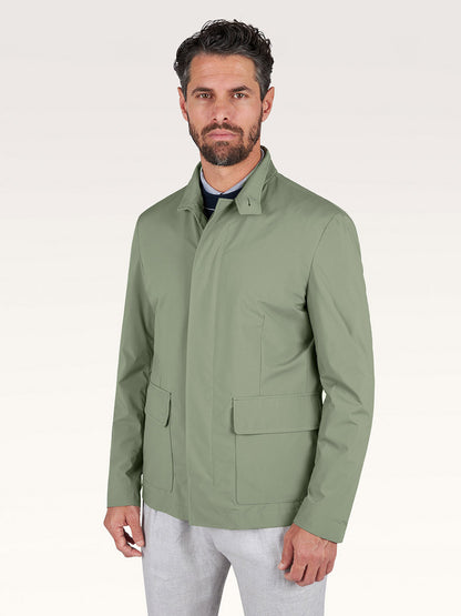 A man with short dark hair and a beard wears the Paul & Shark Typhoon® Platinum Car Coat with Aqualeather suede details in olive over a collared shirt and light trousers, standing against a plain background.