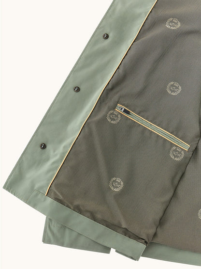 Close-up of the Paul & Shark Typhoon® Platinum Car Coat With Aqualeather Suede Details in Olive, showing a zippered pocket and patterned lining with repeated laurel wreath designs.