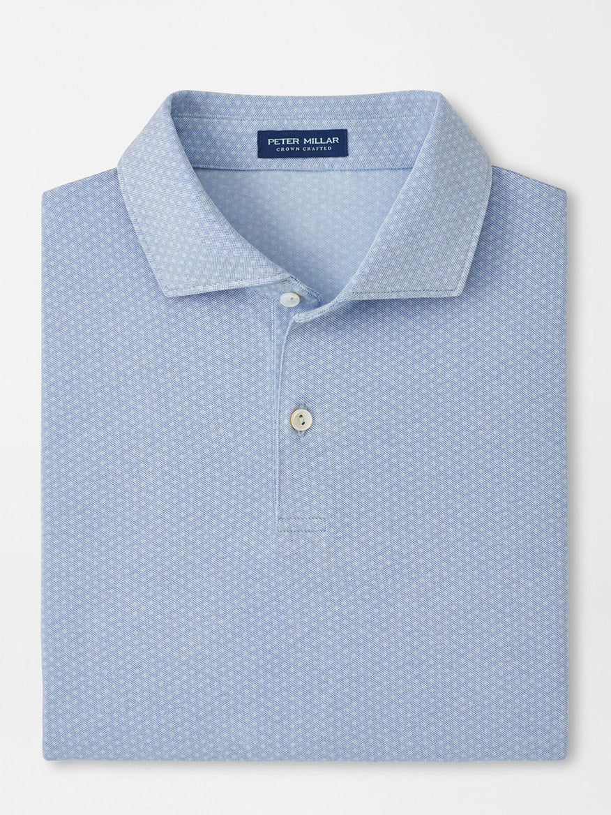 A neatly folded Peter Millar Albatross Diamond Cotton-Blend Piqué Polo in Dusk Blue features a subtle geometric pattern, two white buttons, and a visible brand label inside the collar.