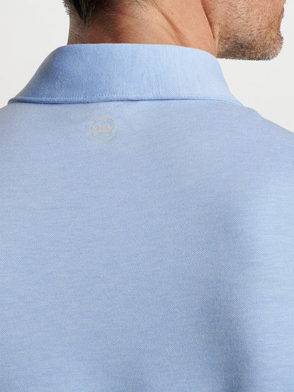 The back view of a man wearing a Peter Millar Albatross Cotton Blend Piqué Polo in Regatta Blue made of performance yarns.