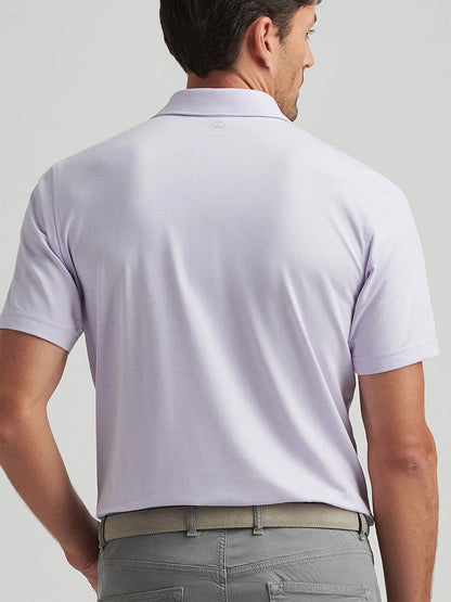 A man in a lavender moon Peter Millar Albatross Cotton Blend Piqué Polo and gray pants is seen from the back against a plain background.