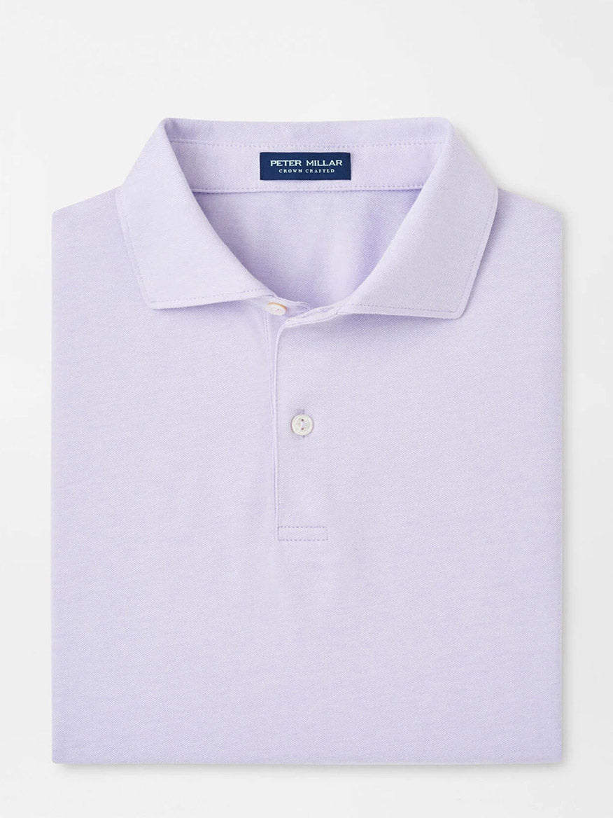 A lavender polo from Peter Millar, called the Albatross Cotton Blend Piqué Polo, neatly folded and made from soft cotton with a buttoned placket.