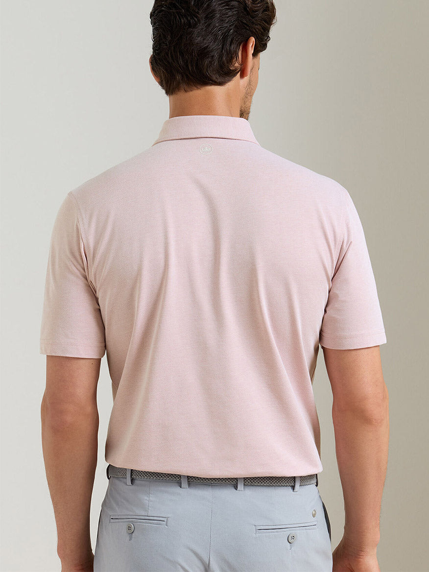 A man wearing a Peter Millar Albatross Cotton Blend Piqué Polo in Faded Scarlet.