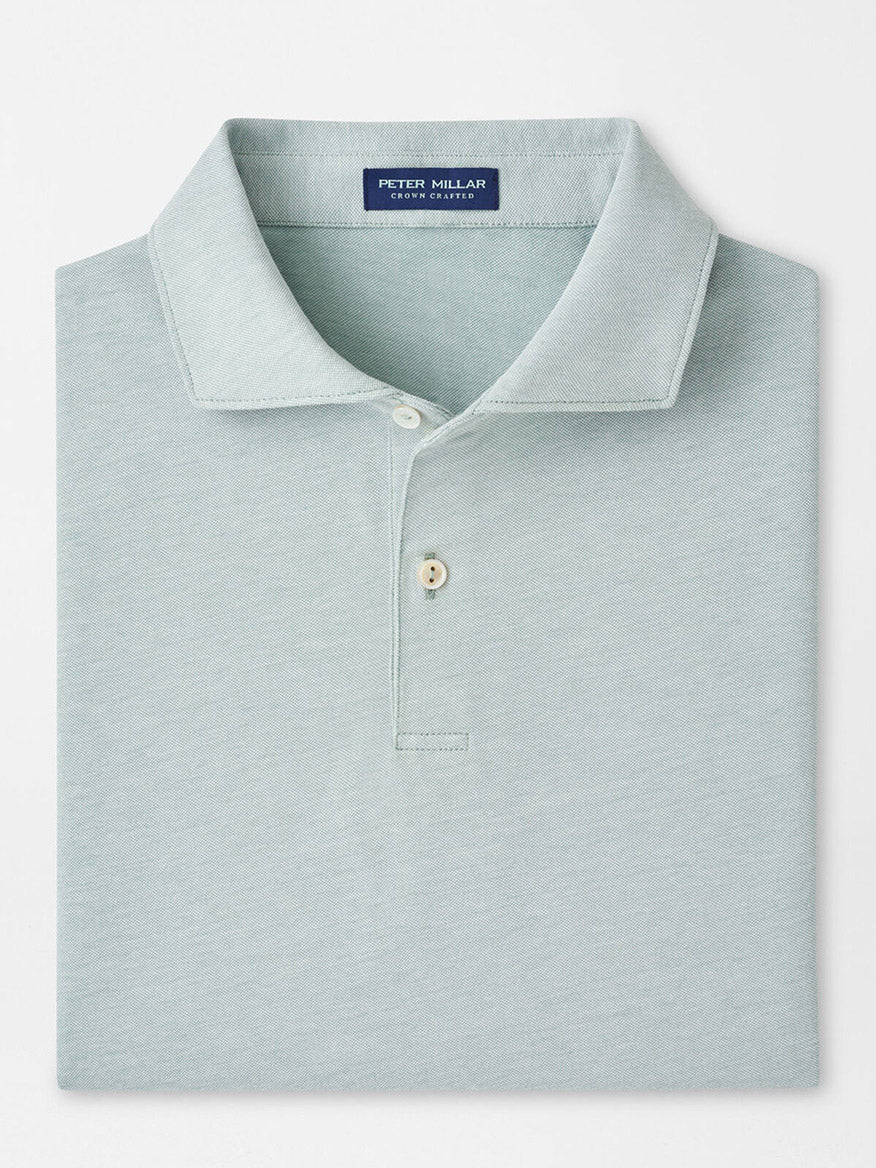 The Peter Millar Albatross Cotton Blend Piqué Polo in Light Willow is neatly folded, featuring a classic collar and two-button placket, made from a comfortable cotton blend fabric.