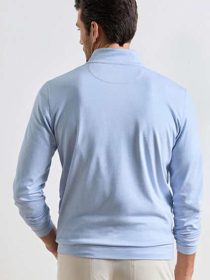 A man wearing the Peter Millar Albatross Cotton-Blend Piqué Quarter-Zip in Dusk Blue faces away from the camera against a plain background.