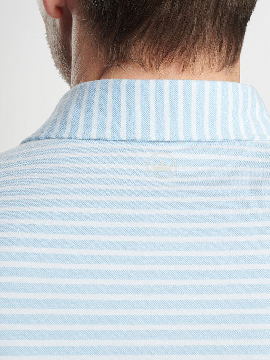 Close-up of the back of a man's shirt, crafted in luxurious cotton blend piqué with light blue horizontal stripes, featuring a collar. This is the Peter Millar Albatross Stripe Polo in Blue Frost.