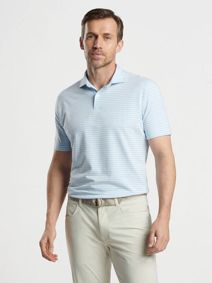 A man in a Peter Millar Albatross Stripe Cotton Blend Piqué Polo in Blue Frost and beige pants stands in front of a plain background.