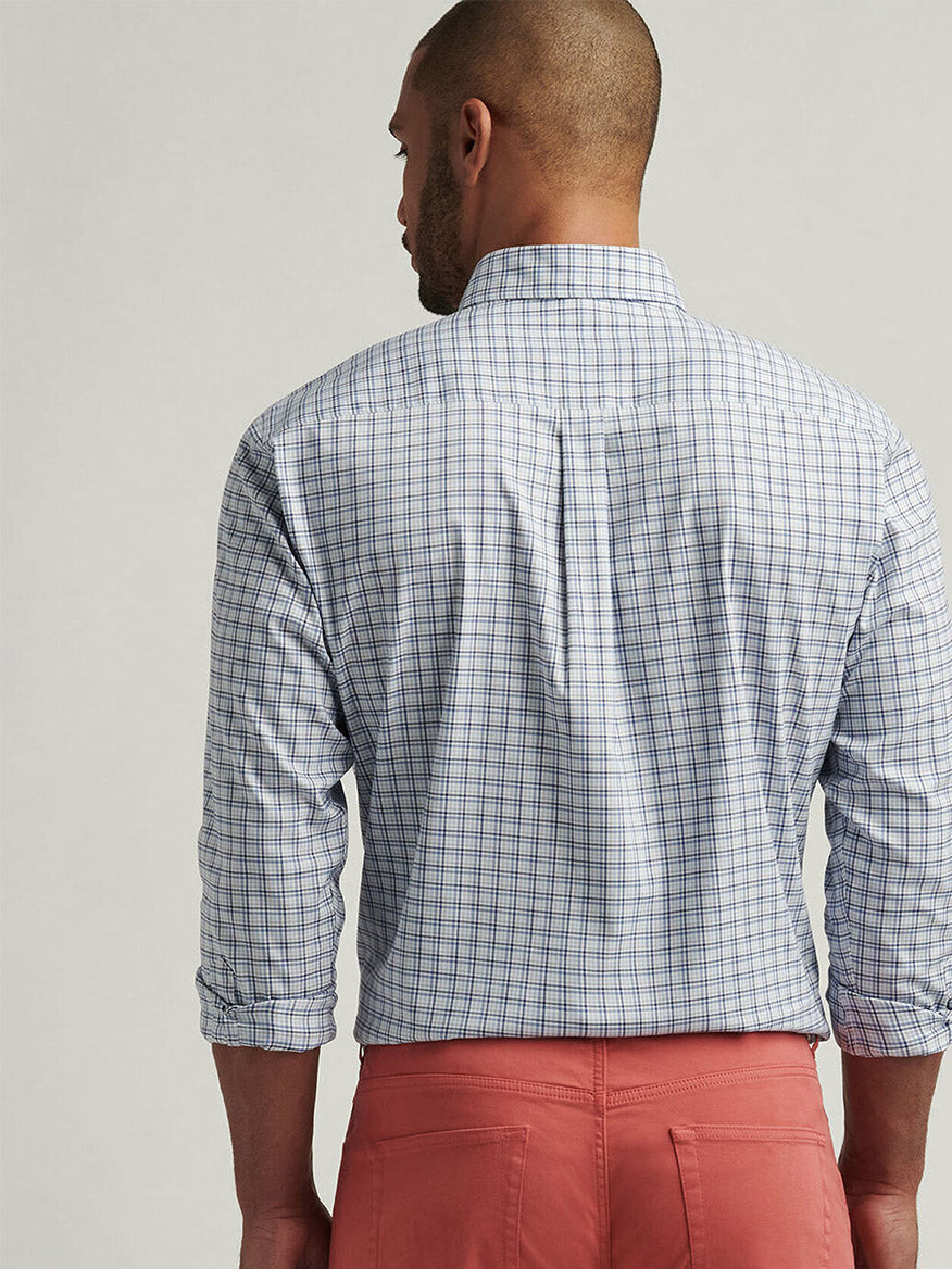 A man is shown from the back in a Peter Millar Albert Crown Lite Cotton-Stretch Sport Shirt in Blue Freesia and pink pants, highlighting the easy-care fabric.