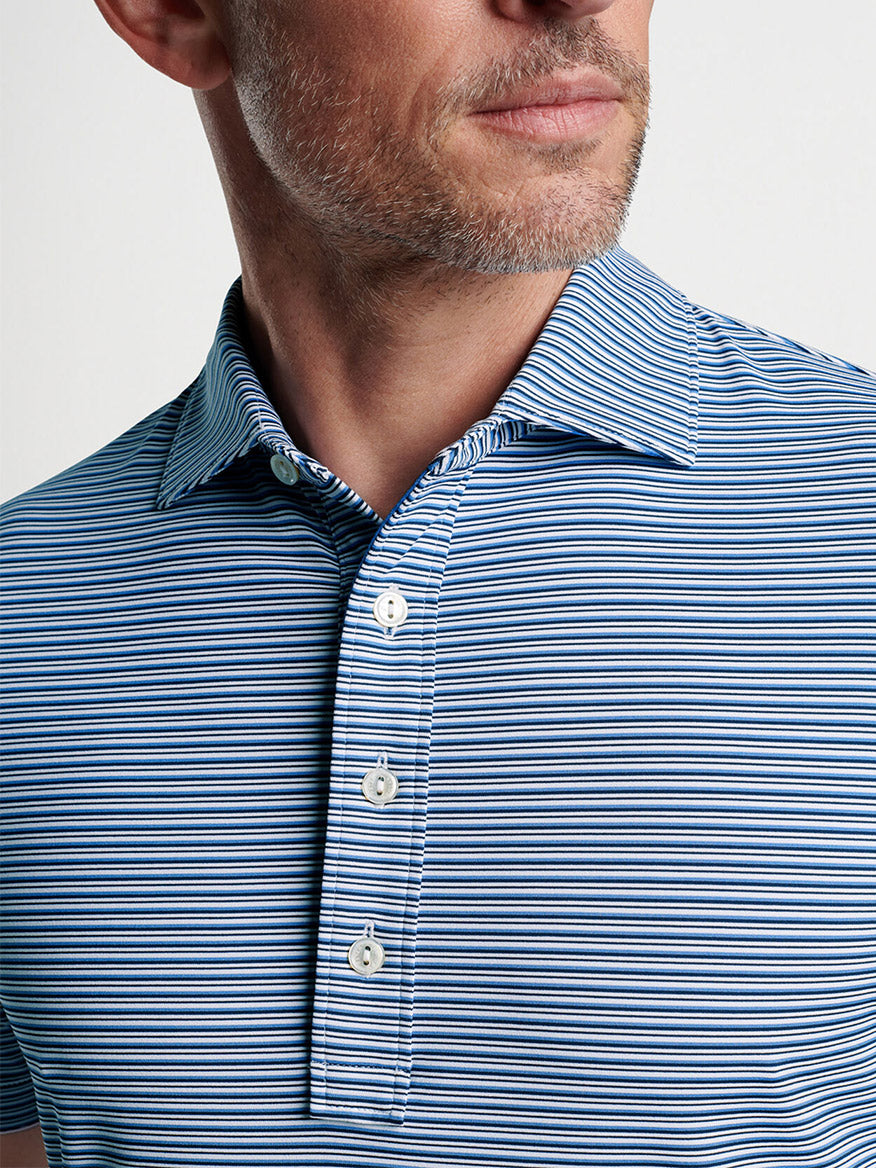 Close-up of a man wearing a Peter Millar Alto Performance Jersey Polo in White/Navy.