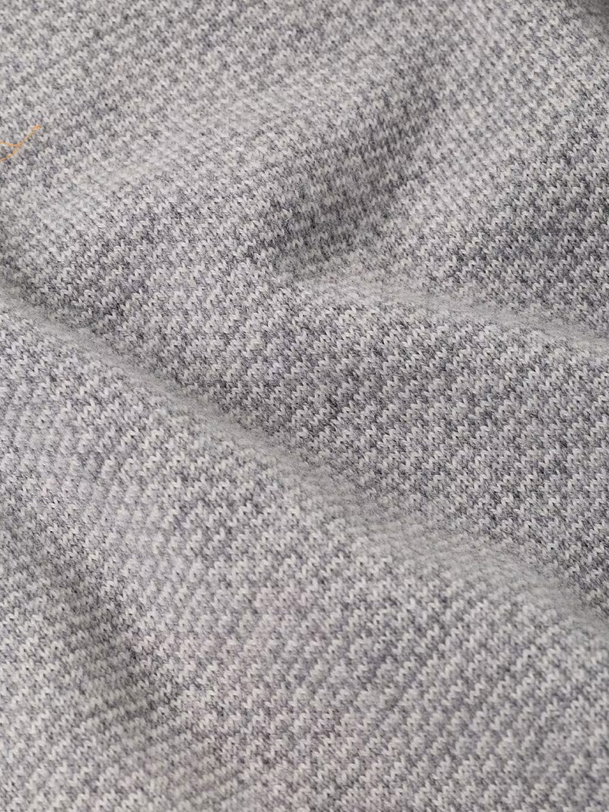 Close-up of the Peter Millar Ashland Quarter-Zip Sweater in Gale Grey, featuring a light gray houndstooth jacquard pattern with visible texture and soft folds, perfect for a tailored fit.
