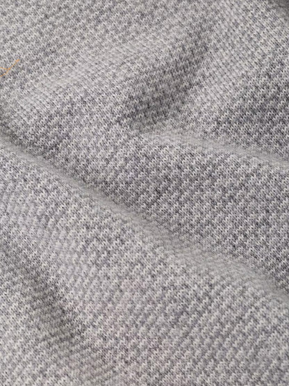 Close-up of the Peter Millar Ashland Quarter-Zip Sweater in Gale Grey, featuring a light gray houndstooth jacquard pattern with visible texture and soft folds, perfect for a tailored fit.