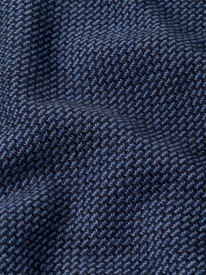 Close-up of the Peter Millar Ashland Quarter-Zip Sweater in Midnight Navy, featuring a dark blue and black houndstooth jacquard pattern with visible texture and slight folds, perfect for a tailored fit.