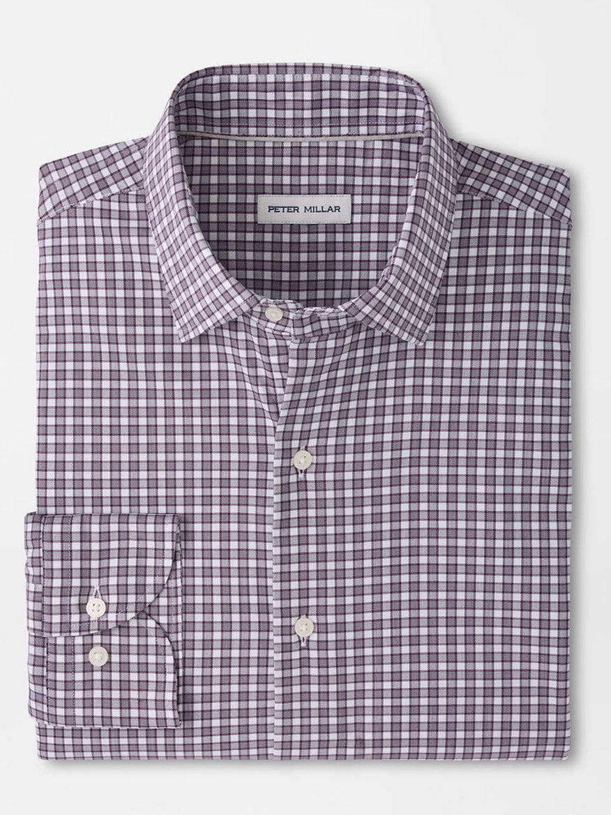 Folded long-sleeve button-up shirt in a purple and white checkered pattern, featuring a front pocket and a visible “Peter Millar” label inside the collar. The Peter Millar Atlas Crown Lite Cotton-Stretch Sport Shirt in Grapeseed is crafted from an easy-care, cotton-stretch twill fabric in a classic fit—perfect for versatile, everyday style.