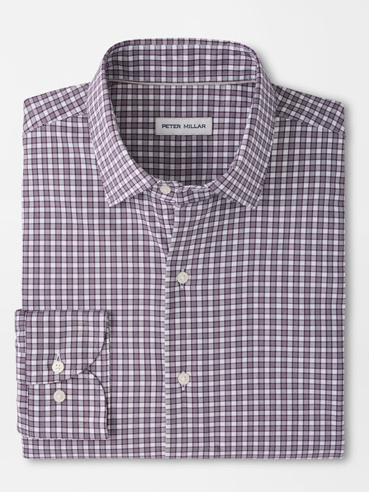 Folded long-sleeve button-up shirt in a purple and white checkered pattern, featuring a front pocket and a visible “Peter Millar” label inside the collar. The Peter Millar Atlas Crown Lite Cotton-Stretch Sport Shirt in Grapeseed is crafted from an easy-care, cotton-stretch twill fabric in a classic fit—perfect for versatile, everyday style.