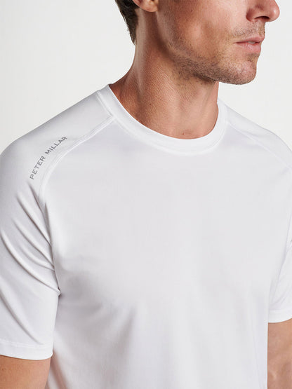 Man wearing a Peter Millar Aurora Performance T-shirt in White with a logo on the sleeve, perfect for the gym.