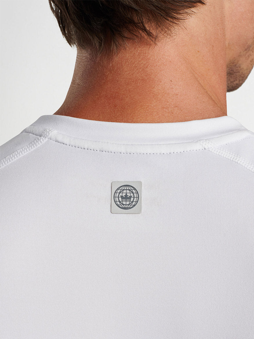 Close-up of the back of a Peter Millar Aurora Performance T-Shirt in White with a small, square logo near the neckline, perfect for the gym.