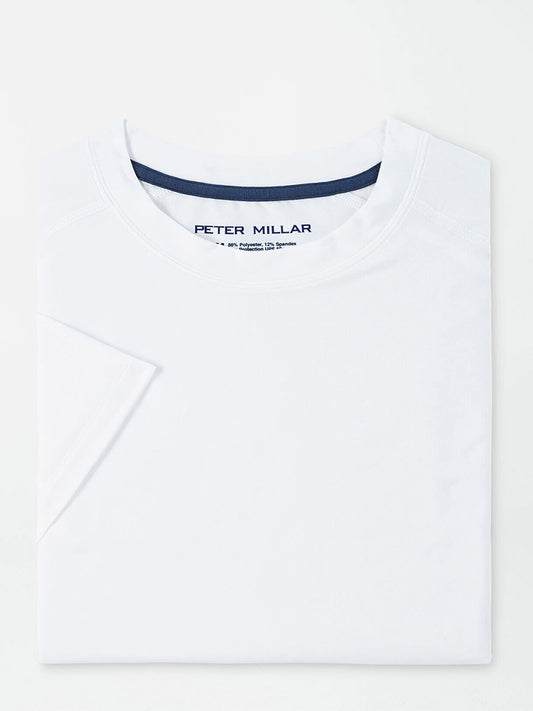 Peter Millar Aurora Performance T-Shirt in White displayed on a flat surface with the brand ‘peter millar’ visible on the inner neckline.
