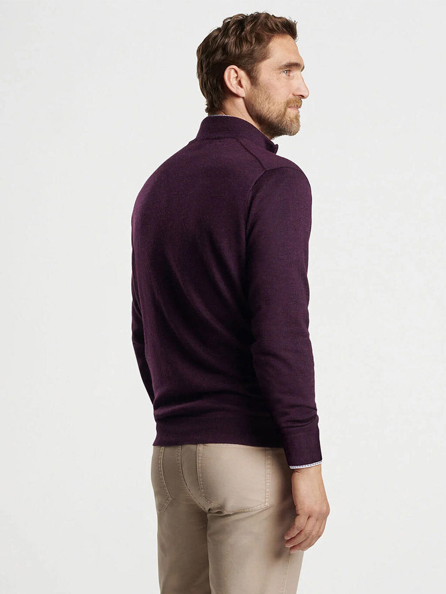 A man wearing a Peter Millar Autumn Crest Quarter-Zip in Dark Plum and beige pants stands slightly to the side against a plain white background.