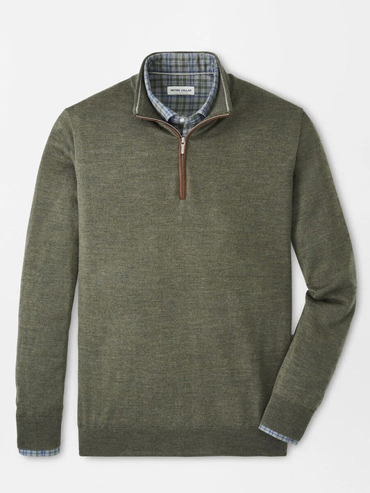 A Peter Millar Autumn Crest Suede Trim Quarter-Zip in Basil, a lightweight olive green sweater with a classic fit, is layered over a blue plaid button-down and displayed neatly on a flat surface.