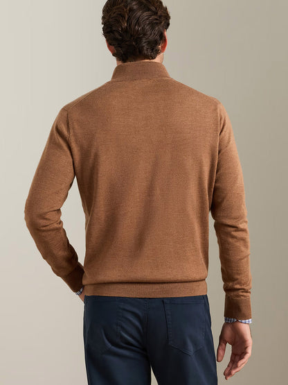 Man wearing the Peter Millar Autumn Crest Suede Trim Quarter-Zip in Dark Amber and navy pants, shown from behind against a plain, light-colored background.