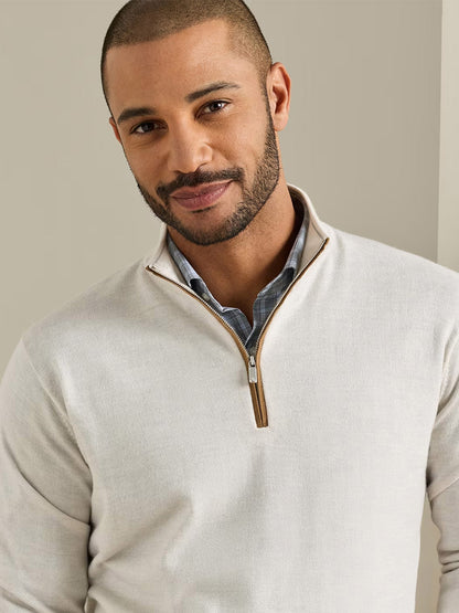Man with close-cropped hair and trimmed beard wearing a Peter Millar Autumn Crest Suede Trim Quarter-Zip in Ivory over a collared shirt, standing against a neutral background.