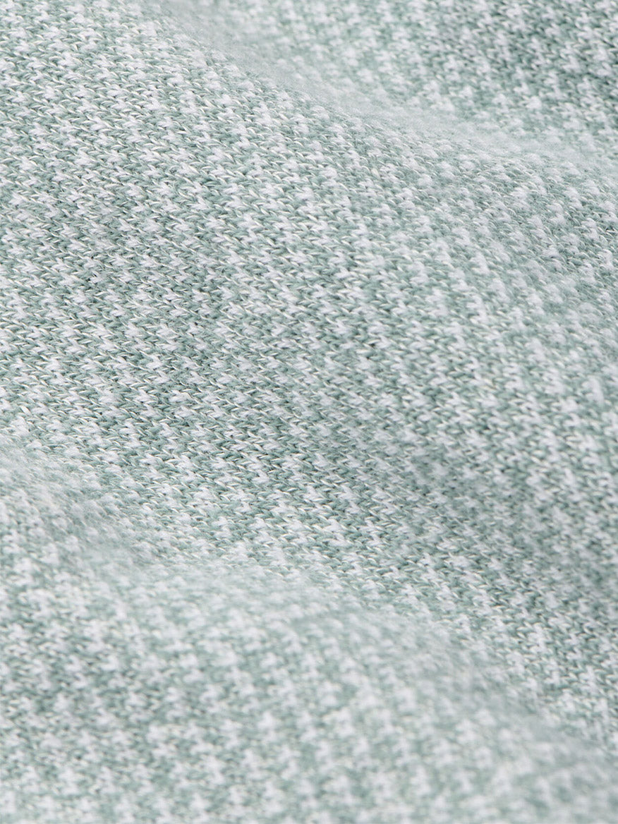 Close-up of the Peter Millar Barlow Quarter-Zip Sweater in Willow, showcasing its soft, light gray and white birdseye jacquard knit with a textured, slightly wavy surface—perfect for making a statement.