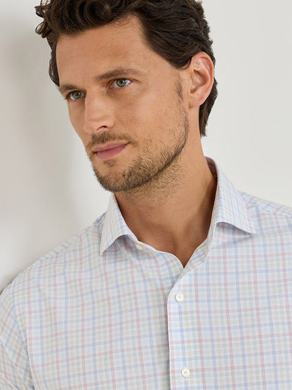 Man with short brown hair and light stubble wears the Peter Millar Basin Performance Poplin Sport Shirt in Multi, featuring performance fabric, against a plain white background.