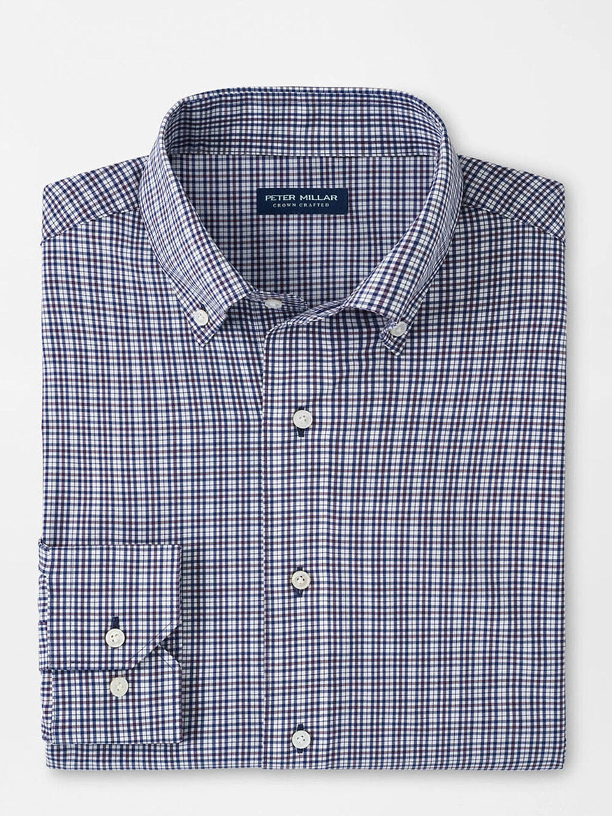 The Peter Millar Berkshire Performance Poplin Sport Shirt in Navy is a neatly folded, blue and white checkered button-down with a collar, crafted from soft performance fabric, featuring white buttons and an inner collar label.