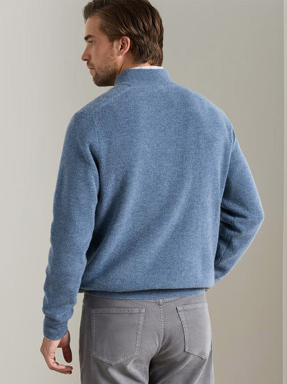 A man wearing a Peter Millar Blackburn Button-Mock Sweater in Summer Rain and gray pants stands facing away from the camera against a plain indoor background.