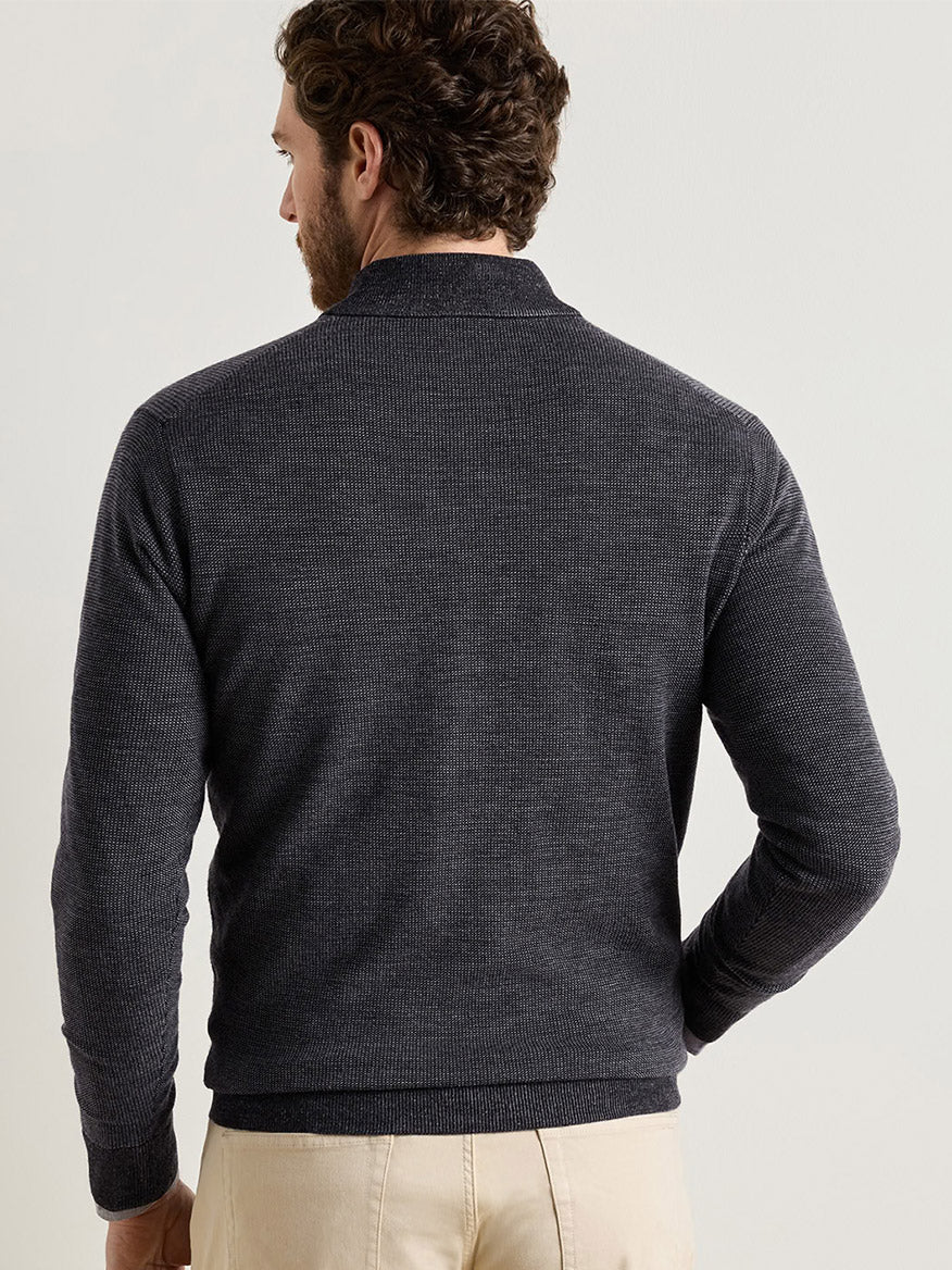 A man viewed from the back wearing a charcoal Peter Millar Blair Birdseye Quarter-Zip Sweater in a classic fit with a textured birdseye stitch.