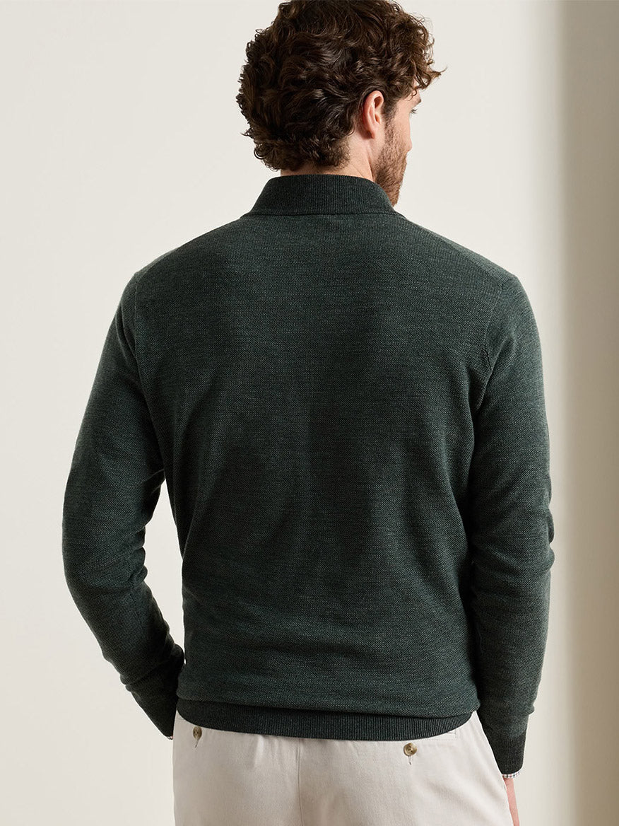 Back view of a man wearing a dark green Peter Millar Blair Birdseye Quarter-Zip Sweater in Pine Brook, featuring a classic fit.
