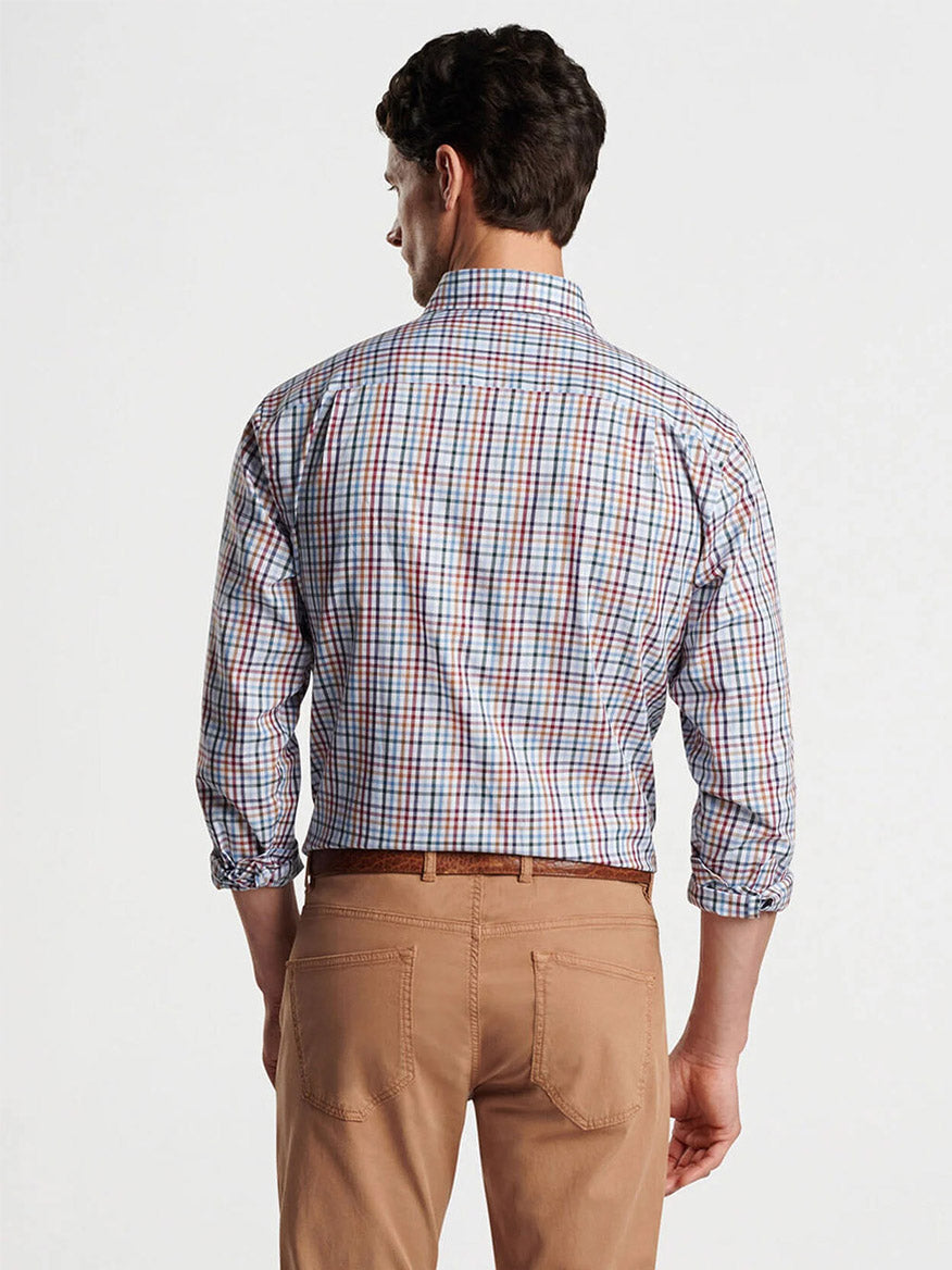 A man is standing with his back to the camera, wearing a tailored fit Peter Millar Brighton Cotton Sport Shirt in Navy and tan pants.