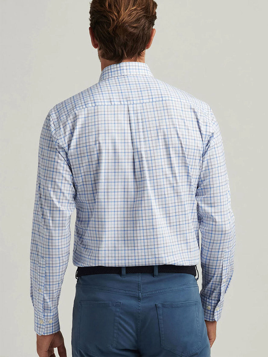 Back view of a person wearing the Peter Millar Calgary Crown Lite Cotton-Stretch Sport Shirt in Blue Poppy, paired with blue pants.