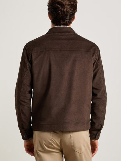 A man stands with his back to the camera, wearing the Peter Millar Camden Corduroy Jacket in French Press paired with light khaki pants against a plain background—perfect for lightweight layering.