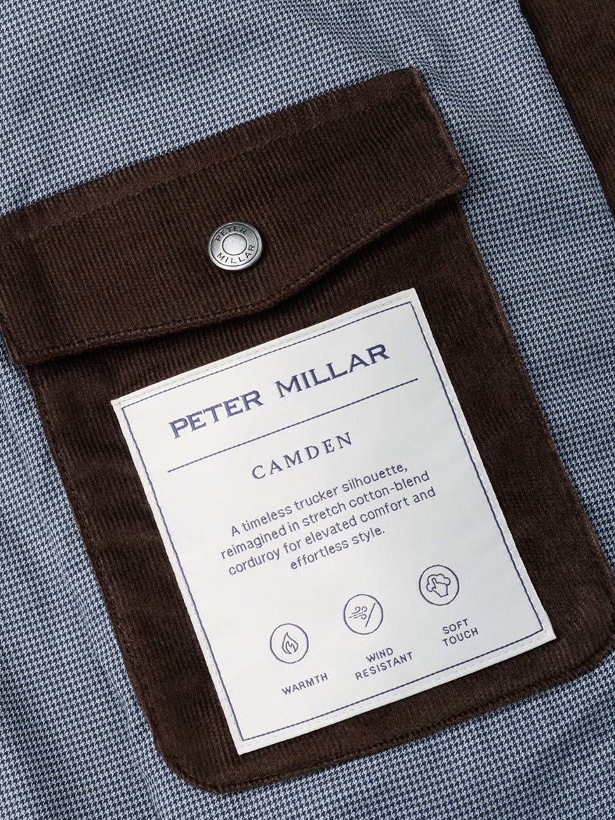 Close-up of the Peter Millar Camden Corduroy Jacket in French Press, featuring a brown corduroy pocket with a metal snap and signature label—designed for comfort, warmth, wind resistance, and a soft touch, making it ideal for lightweight layering or as a versatile update to the classic fit corduroy trucker jacket.
