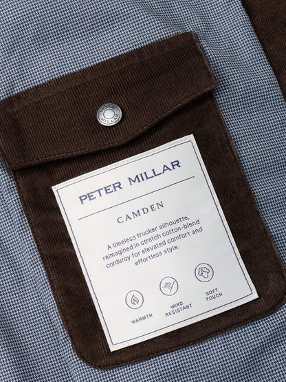 Close-up of the Peter Millar Camden Corduroy Jacket in French Press, featuring a brown corduroy pocket with a metal snap and signature label—designed for comfort, warmth, wind resistance, and a soft touch, making it ideal for lightweight layering or as a versatile update to the classic fit corduroy trucker jacket.