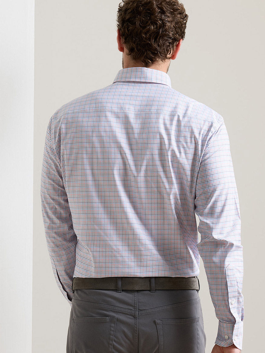 A man is shown from the back indoors, wearing the Peter Millar Casey Performance Twill Sport Shirt in Navy and gray trousers.