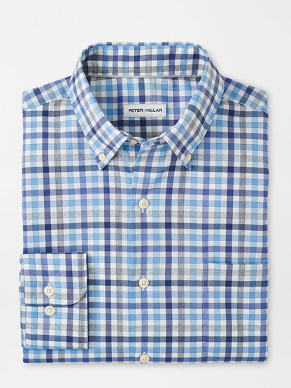 A folded Peter Millar Chambly Crown Lite Cotton-Stretch Sport Shirt in White, featuring blue and white checkered patterns and a visible label reading "Peter Millar," offering UPF 50+ sun protection to keep you safe in the sun.