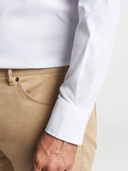 Close-up of a person wearing a Peter Millar Collins Performance Oxford Sport Shirt in White and beige trousers.