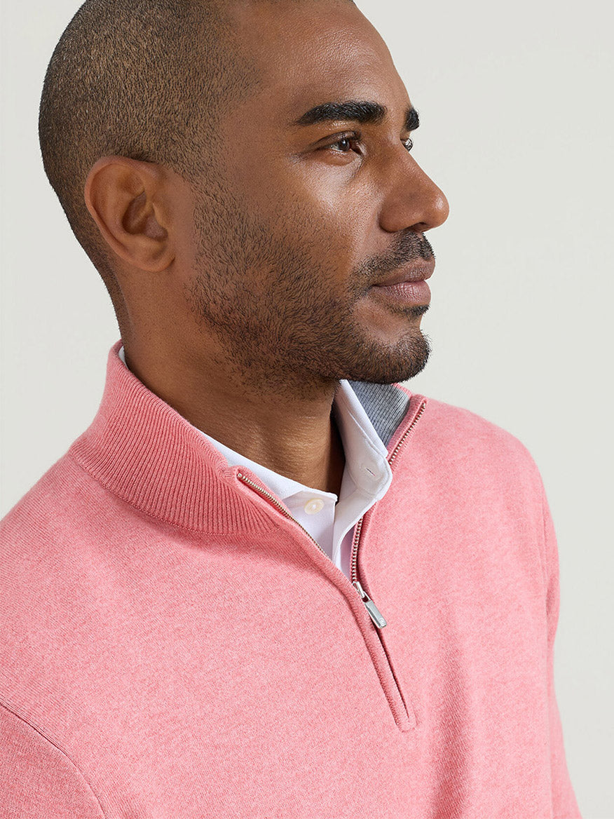 Man wearing a Peter Millar Coolspun Lite Cotton Quarter-Zip Sweater in Venetian Pink over a white collared shirt, looking to the side against a plain background.