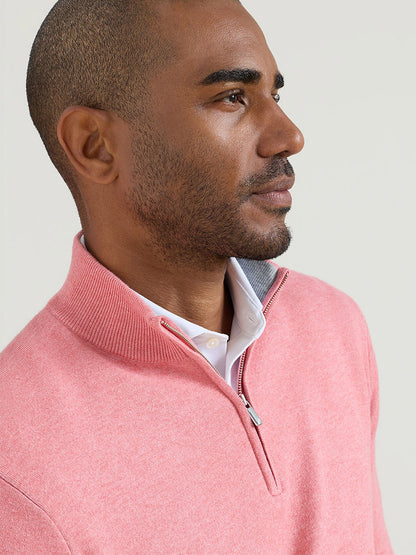 Man wearing a Peter Millar Coolspun Lite Cotton Quarter-Zip Sweater in Venetian Pink over a white collared shirt, looking to the side against a plain background.