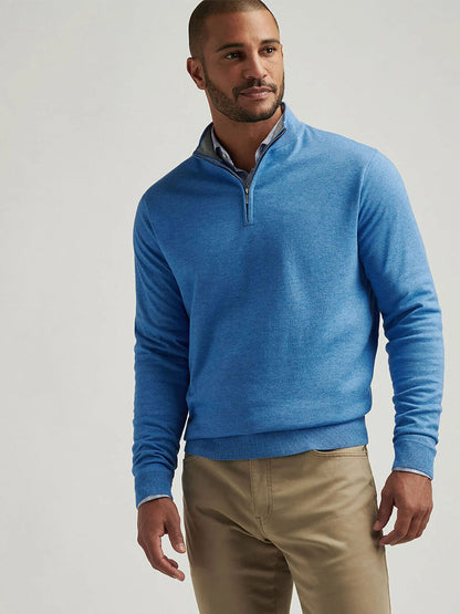 A person in the Peter Millar Coolspun Cotton Quarter-Zip Sweater in Blue Poppy and khaki pants stands against a neutral background, highlighting this versatile piece ideal for any occasion.