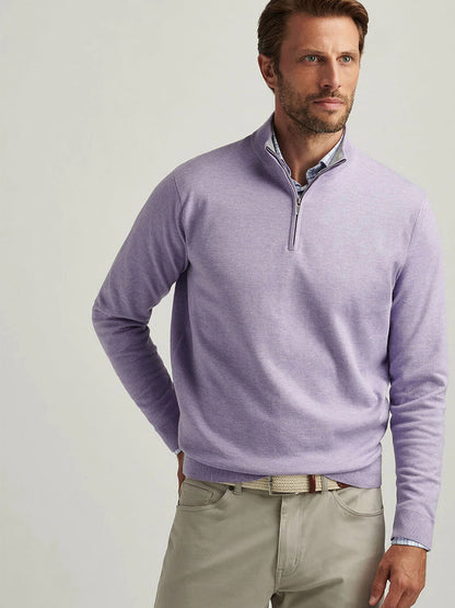 A man in a Peter Millar Coolspun Cotton Quarter-Zip Sweater in Wildflower and beige pants stands against a plain background, looking to the side.